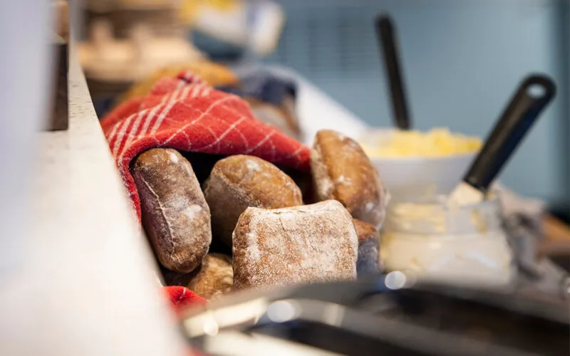 Närbild på frukostbröd och croissanter på buffébord.