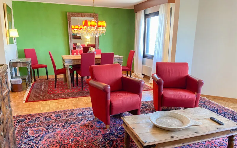 Hotellbadrum med dusch, glasvägg och handduk på bänk.