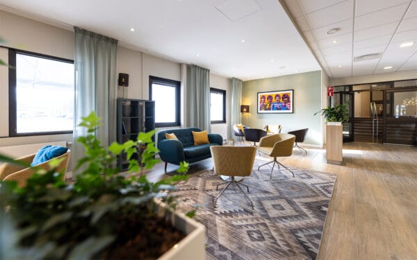 Lounge med soffor, fåtöljer och konst på väggen.