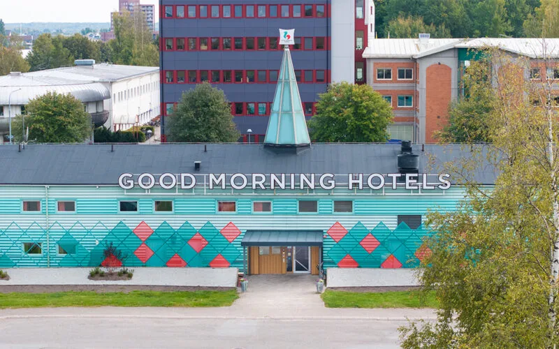 Fasadvy med färgglad geometrisk design och tydlig hotellskylt.