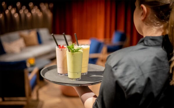 Två färgglada drinkar serverade på bricka