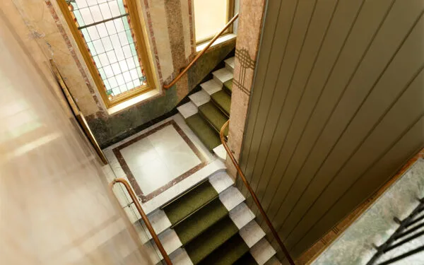 Historisk trappa med stora fönster och träräcken.