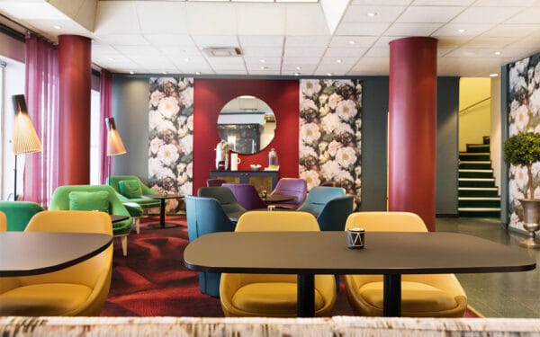 Lobby med färgglada stolar och blommiga väggdetaljer