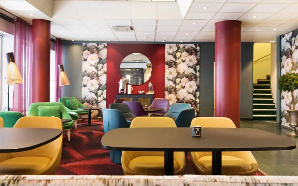 Lobby med färgglada stolar och blommiga väggdetaljer