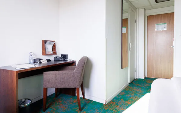 Arbetsplats med skrivbord, stol och spegel i hotellrum