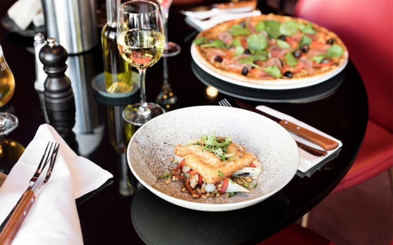 Tallrik med fiskrätt och vin på hotellrestaurang