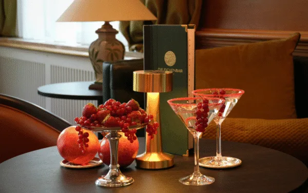 Bartisch mit Getränken, eine Lampe, eine Karte und rote Früchten