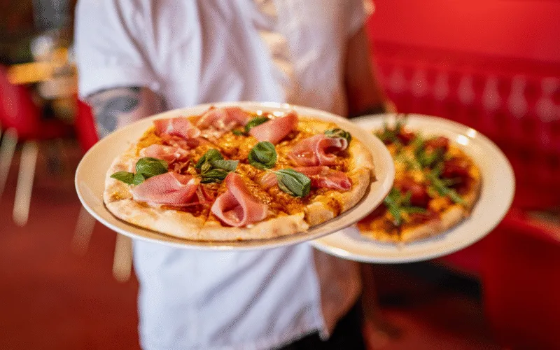 Pizza med parmaskinka och basilika serverad på Restaurang Angelini