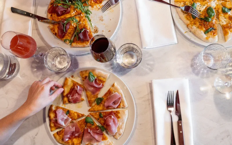 Flera olika pizzor på Restaurang Angelini serverat med rödvin