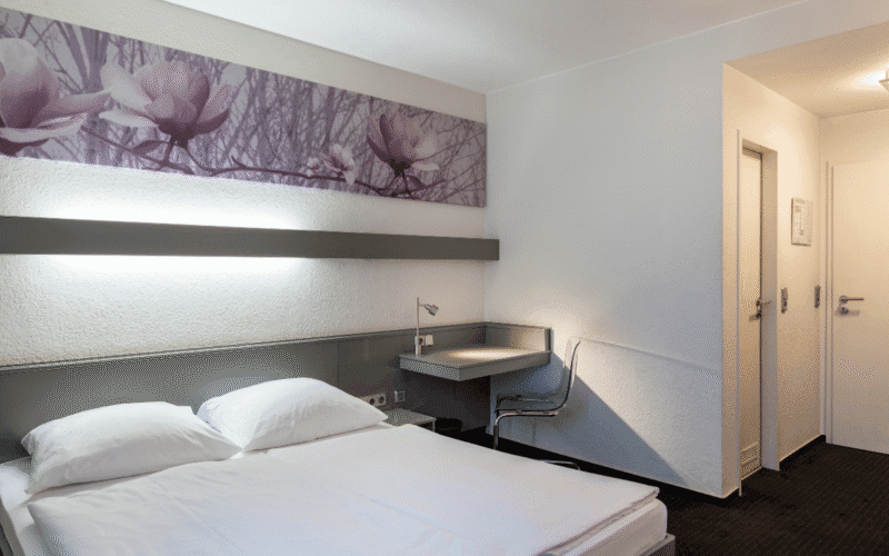 Doppelzimmer mit Doppelbett, Schreibtisch und Stuhl