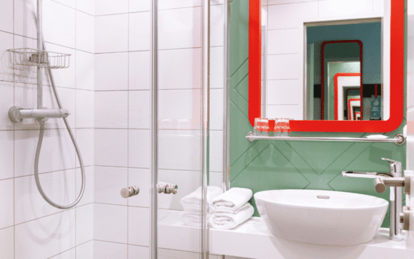 Spiegel mit rotem Rand, Aqua marine grüne Wand Farbe und moderner Porzellan Wachsbecken.