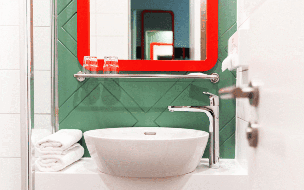 Spiegel mit rotem Rand, Aqua marine grüne Wand Farbe und moderner Porzellan Wachsbecken.