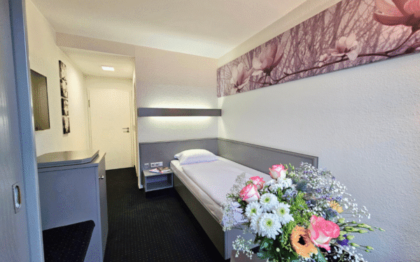 Einzelzimmer, mit Einzelbett, Wanddekoration und Blumen