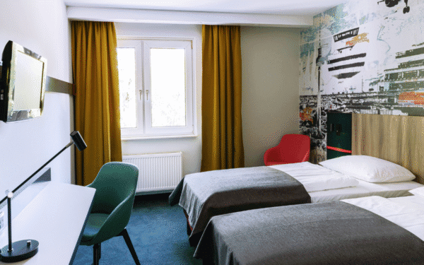 Zimmer mit zwei Einzelbetten, einem Schreibtisch und zwei Stühle