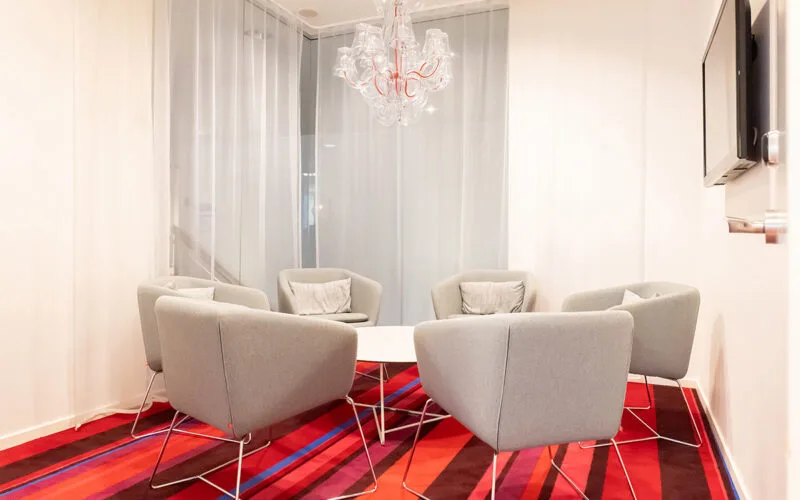 Mötesrum med fåtöljer och litet bord.