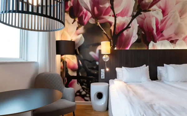 Hotellrum med dubbelsäng och sittgrupp vid fönstret.