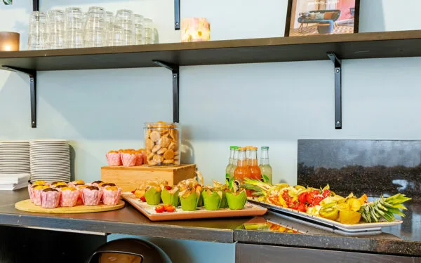 Konferensbuffé med bakverk, frukt och dryck.