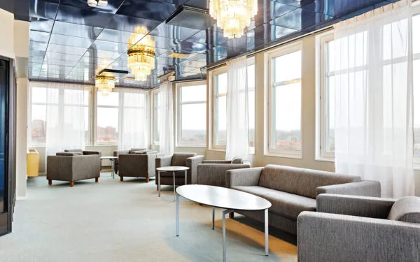 Stilfull lounge med panoramafönster, kristallkronor och bekväma sittplatser.
