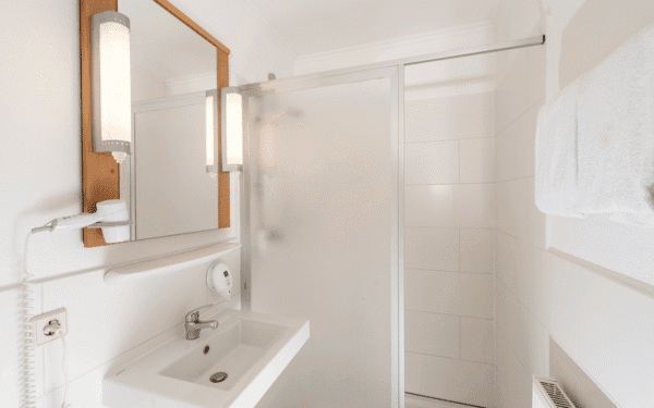 Bad mit Waschbecken, Spiegel und Dusche