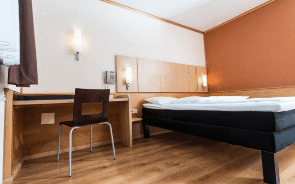 Hotelzimmer mit einem Bett, Schreibtisch und Stuhl