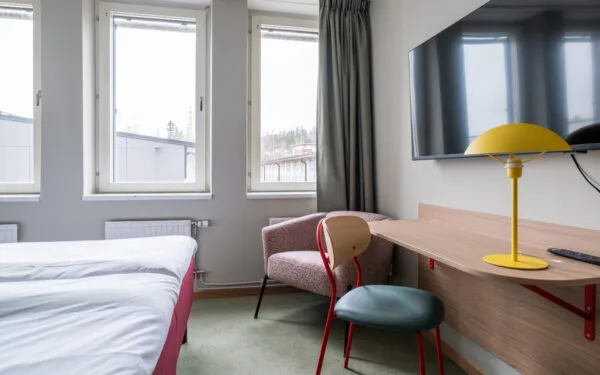 Familjerum på hotellet med skrivbord och stolar samt fotölj och tv