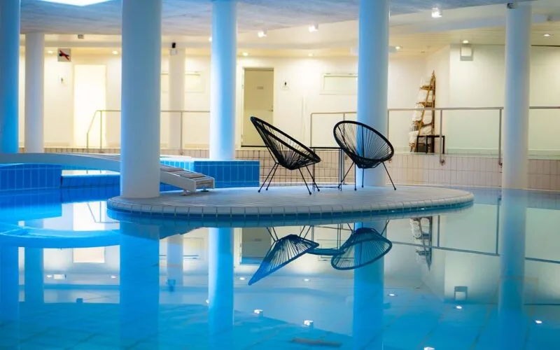 Hotellets pool med to lænestole stående på en ø