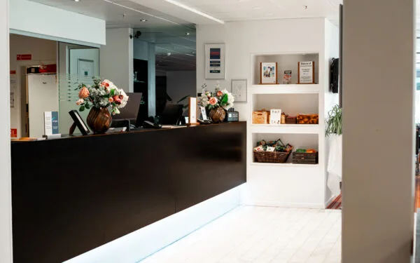 Hotellets reception med blomster på skranken