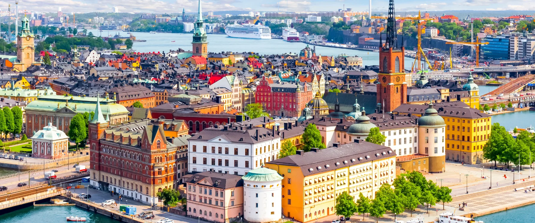 Utsikt över Gamla stan och Stockholms inlopp med färgglada byggnader och kryssningsfartyg.