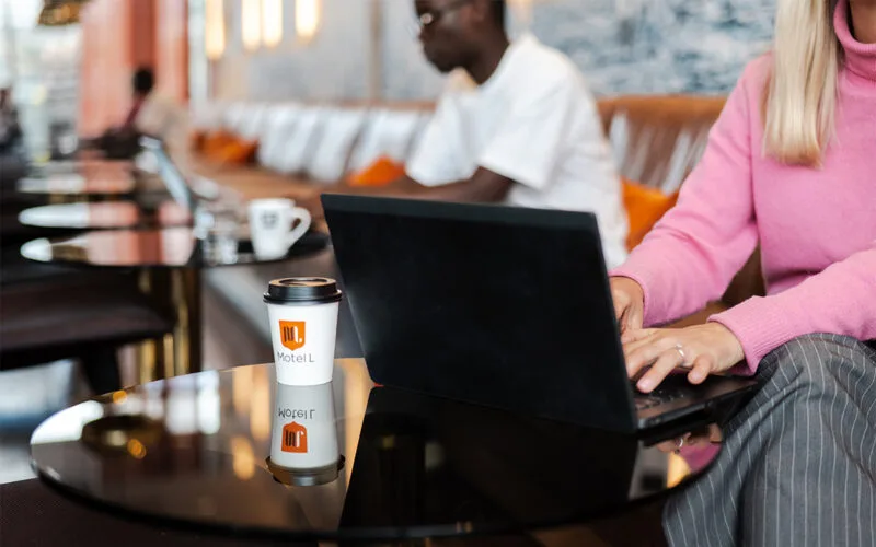 Gäster sitter i hotellobbyn och njuter av lättare tilltugg i en färgstark och avslappnad miljö.