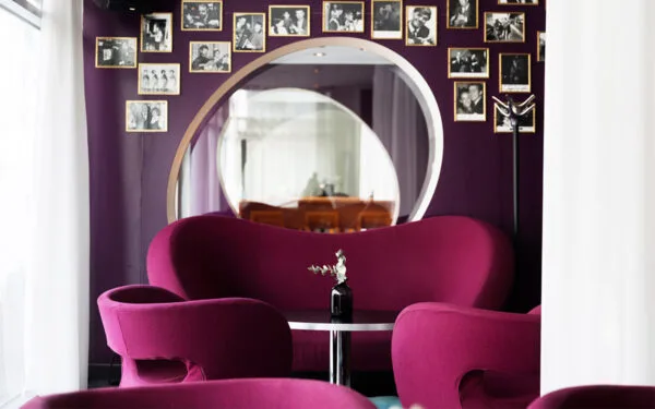 Lila loungehörna med dekorativa foton på väggen.