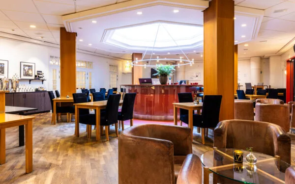 Restaurang och bar med trädetaljer, bord och bekväma sittplatser i varm belysning