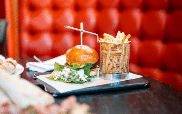 Hamburgare med pommes och sallad serverad i Restaurang Angelini