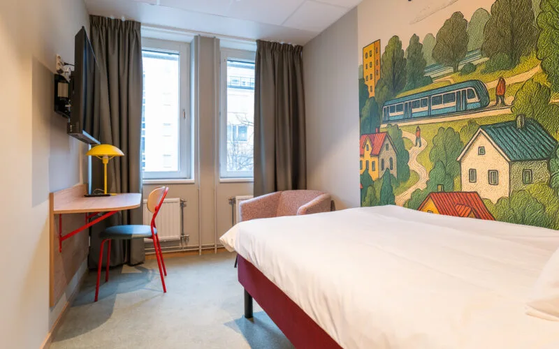 Utsikt över enkelrum med säng och fotölj