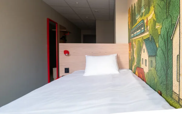 Utsikt över enkelrum med säng och fotölj