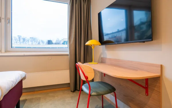 Skrivbord med stol och lampa, samt tv på väggen