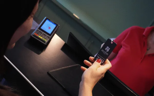 Hotelmitarbeiter übergibt Schlüssel beim Check-in an der Rezeption.