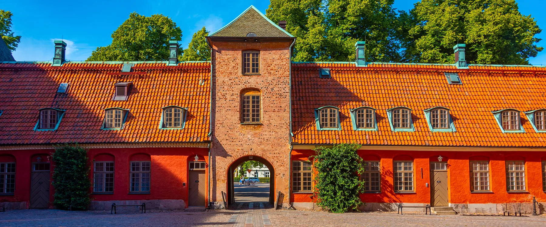 Halmstad slott i tegel med rött tak och en portgång i mitten.