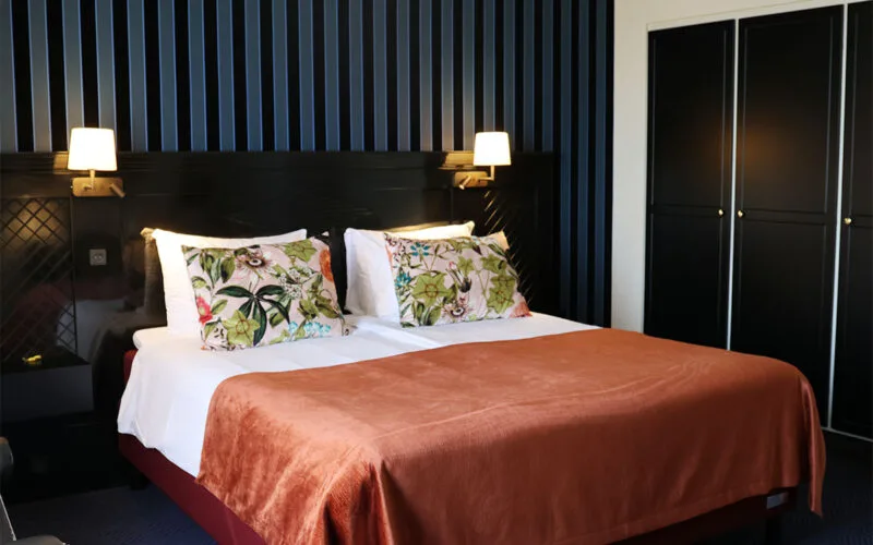 Stor dobbeltseng med to lamper og en smuk bagvæg