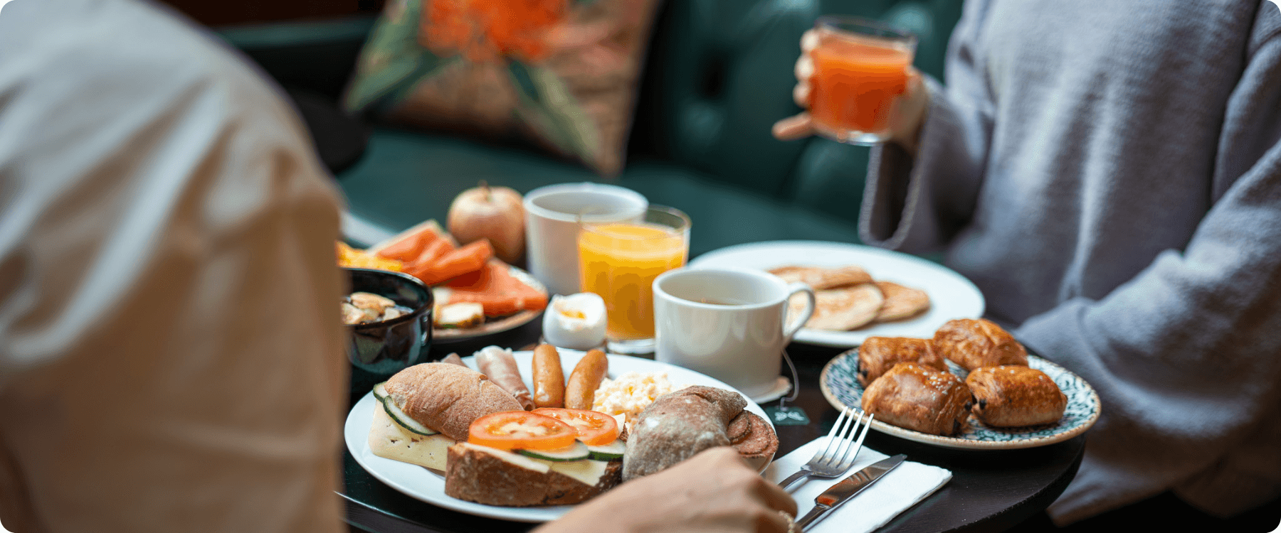 Frukostbord med kaffe, juice, smörgås, äggröra, pannkakor och mycket mer.