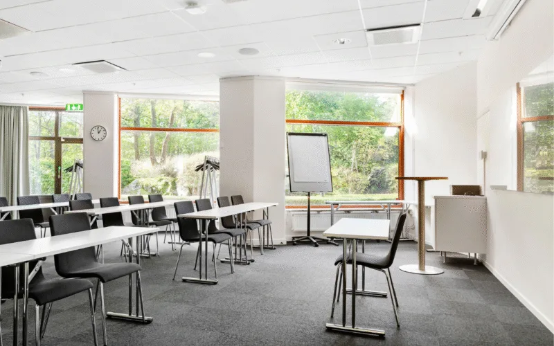 Ett ljust mötesrum med stora fönster med grönska utanför.