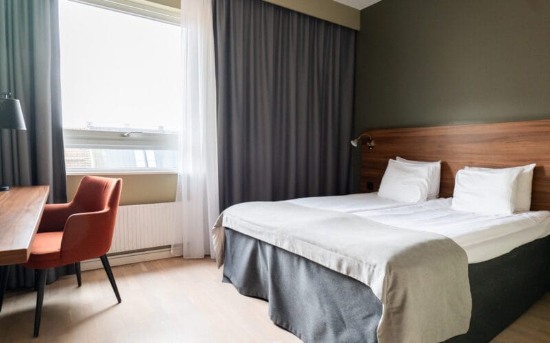 Säng på hotellrummet med skrivbord